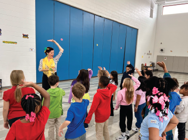students and teacher dancing native dance